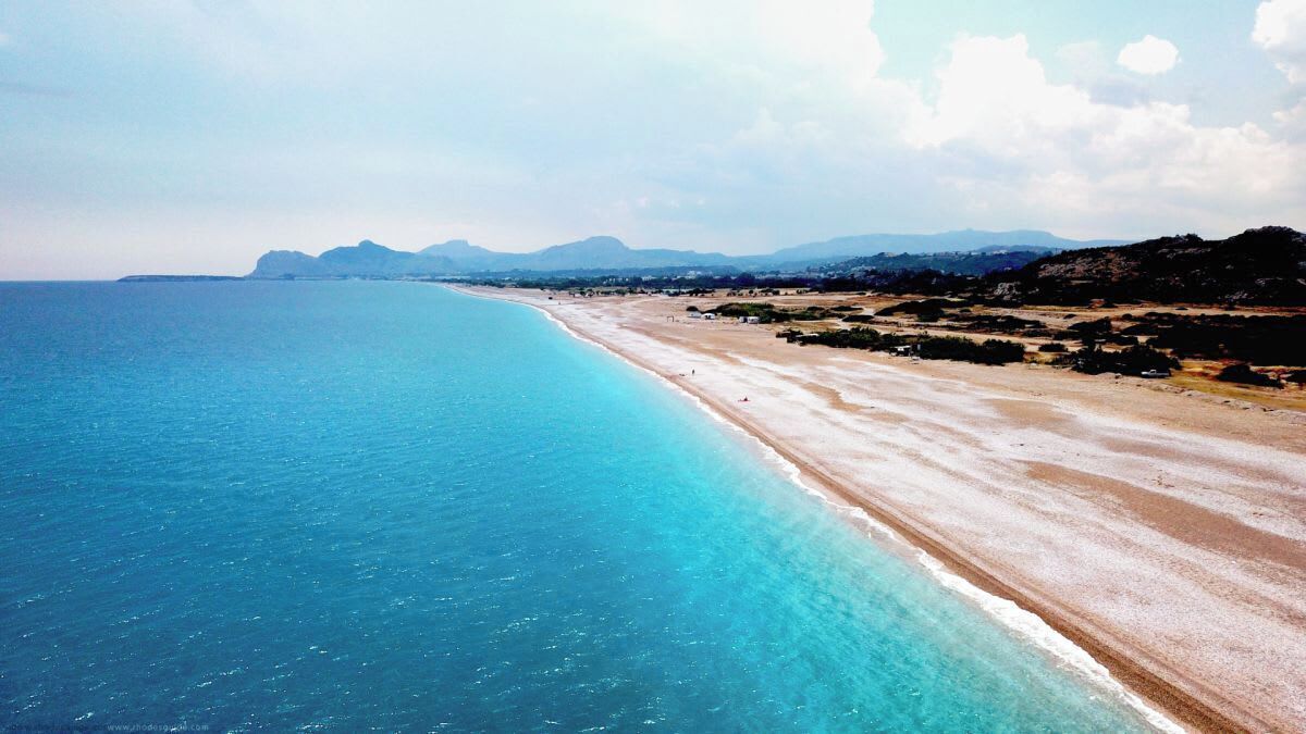 Ein Küstenstrand mit klarem, blauem Wasser und einem Sandufer.