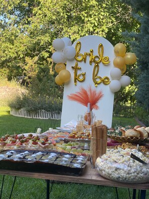 A table with various food items and a 'bride to be' sign.
