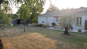 A residential property with a well-maintained lawn, a small tree, and a house with a tiled roof. - Country house (Clam)