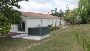 A residential building with a tiled roof, a large black water heater, and a well-maintained lawn. - Country house (Clam)