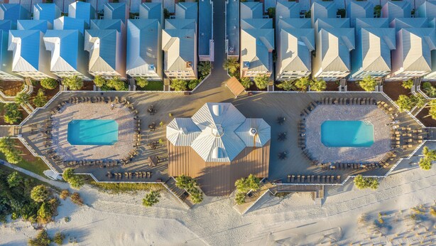 An aerial view of a resort with multiple buildings, two swimming pools, and a central courtyard. - Stay @ The Grand in Wild Dunes (Isle Of Palms)