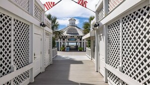 A wooden walkway leading to a building with a white lattice facade and a sign reading "Hotel". - Stay @ The Grand in Wild Dunes (Isle Of Palms)