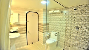 Une salle de bain avec une douche à parois en verre, des toilettes et un lavabo.