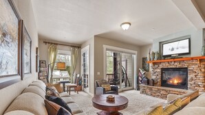 A cozy living room with a fireplace, a large window, and a comfortable seating area. - Spacious Elegance-Kirkwood-Timber Ridge 3 Bedroom 3 Residence (Kirkwood)