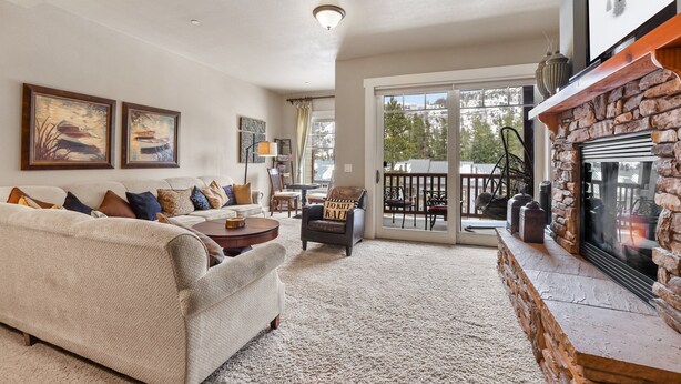 A cozy living room with a fireplace, a large window, and a comfortable seating area. - Spacious Elegance-Kirkwood-Timber Ridge 3 Bedroom 3 Residence (Kirkwood)