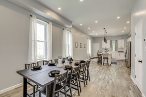 A spacious kitchen with white cabinets, a central island, and pendant lighting.
