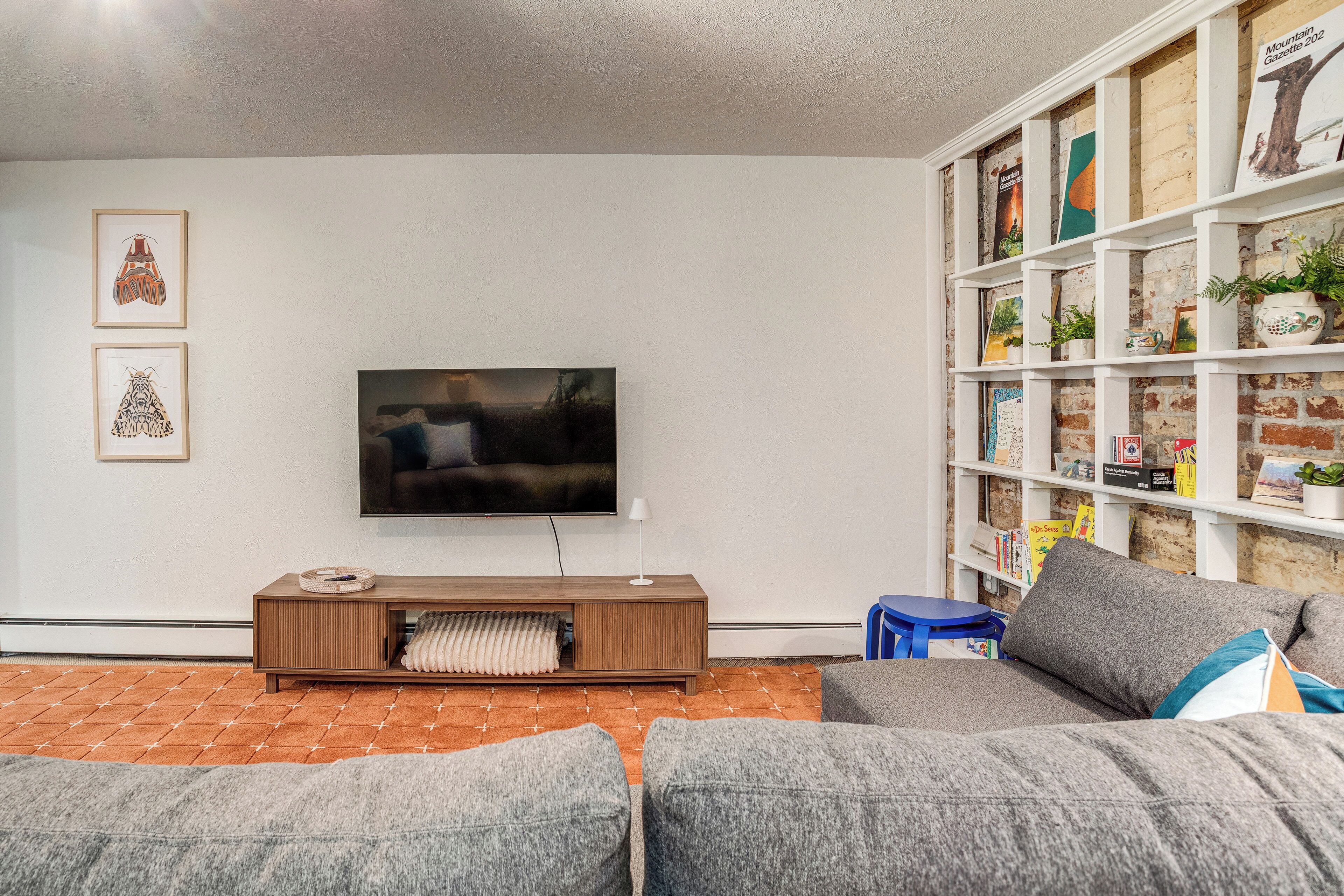 A living room with a TV, a bookshelf, and a sofa.