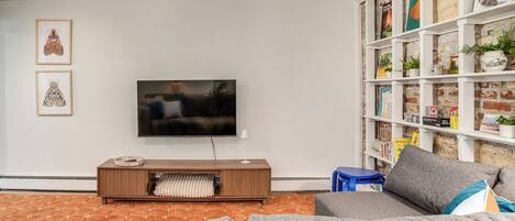 A living room with a TV, a bookshelf, and a sofa.