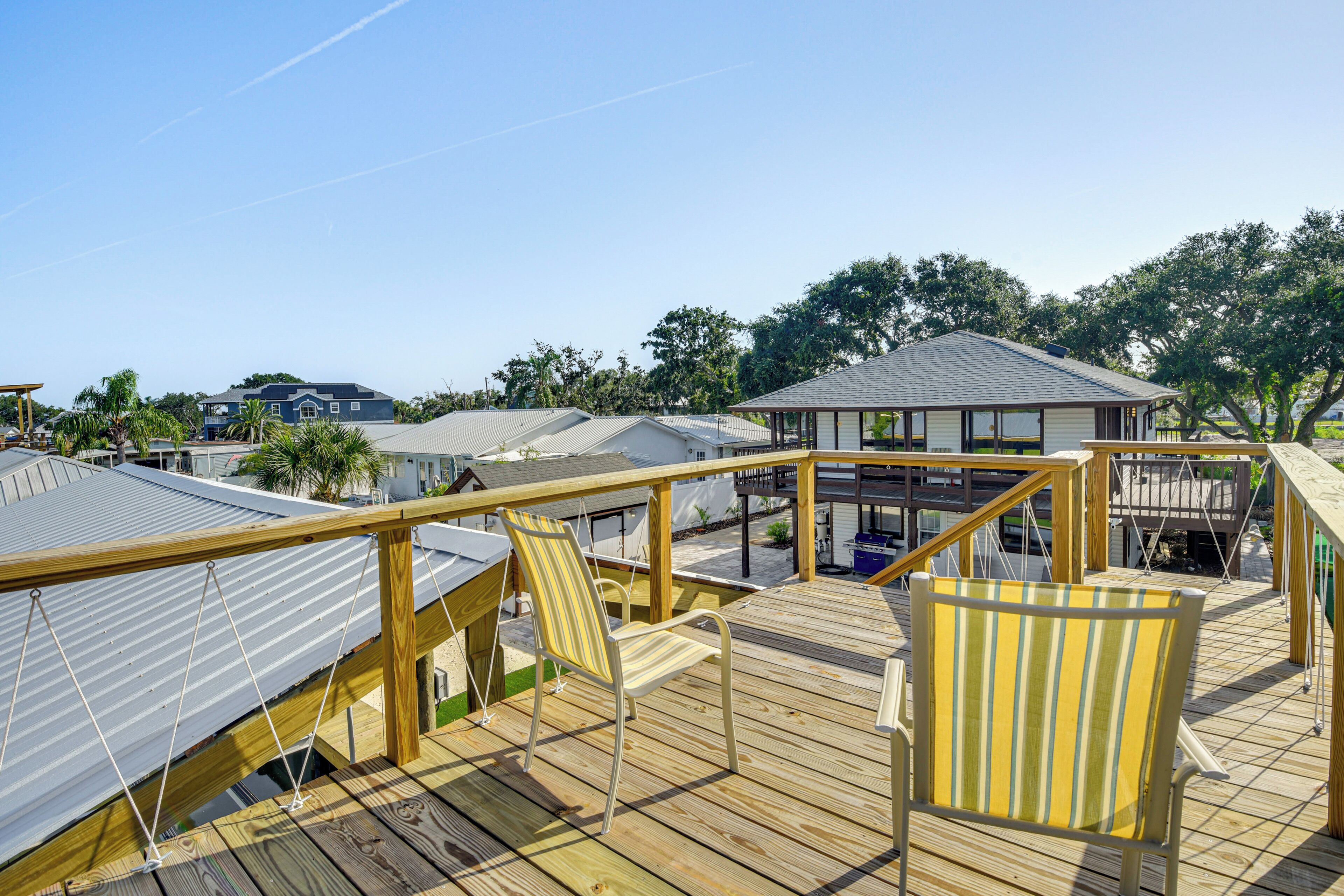 A wooden deck with a railing, a chair, and a small table.