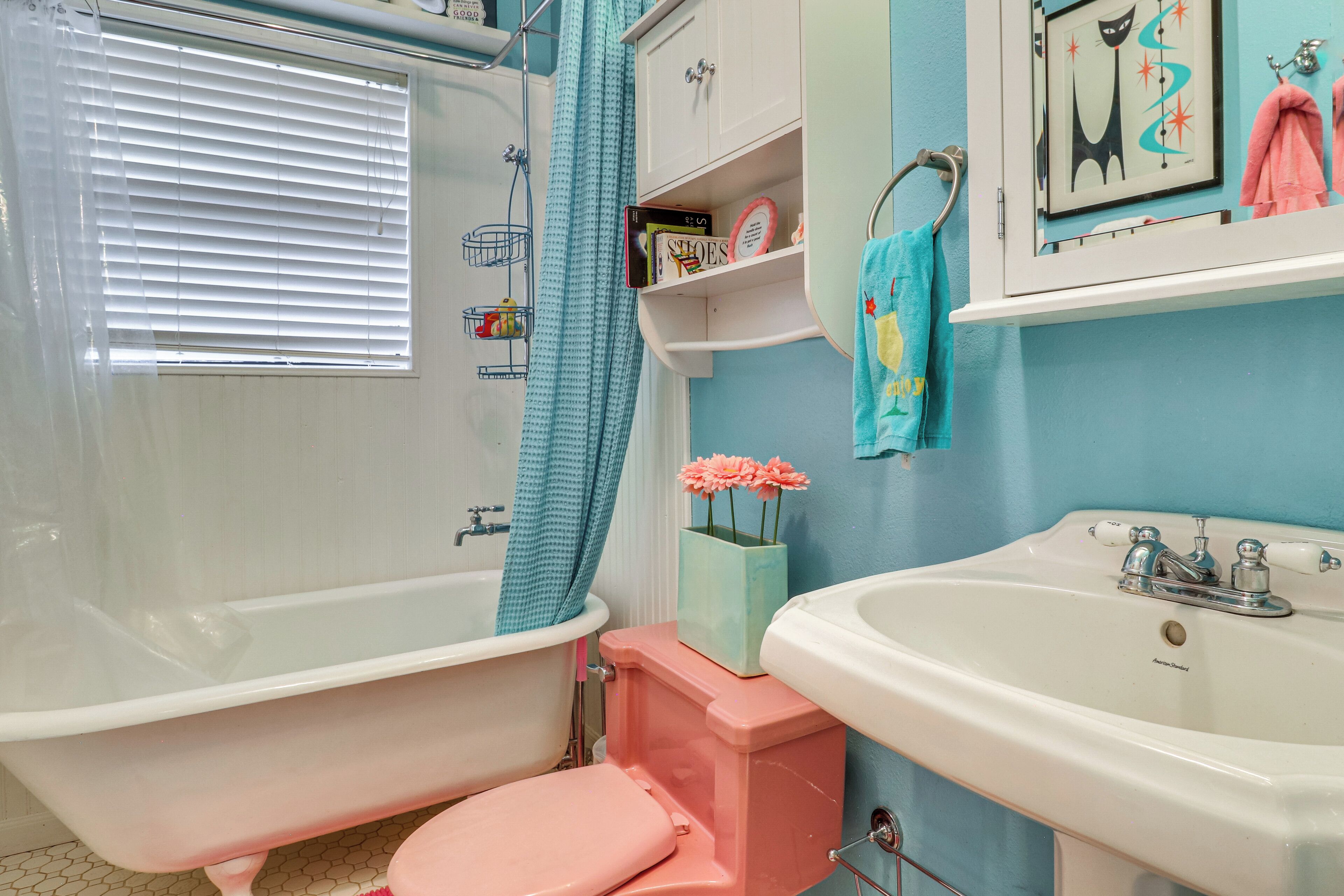 A bathroom with a bathtub, toilet, sink, and a shower curtain.