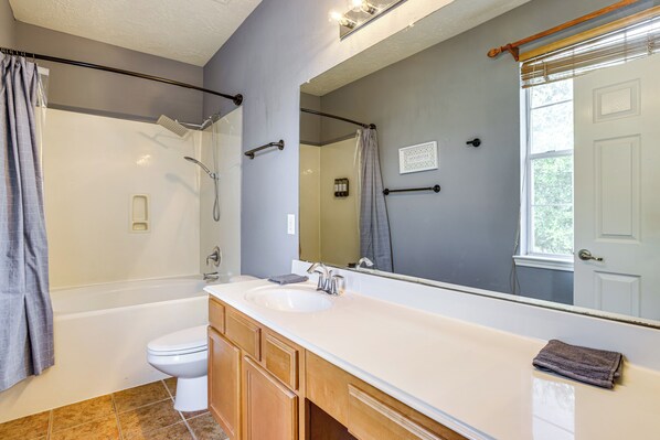 Un baño con bañera, inodoro y lavamanos.