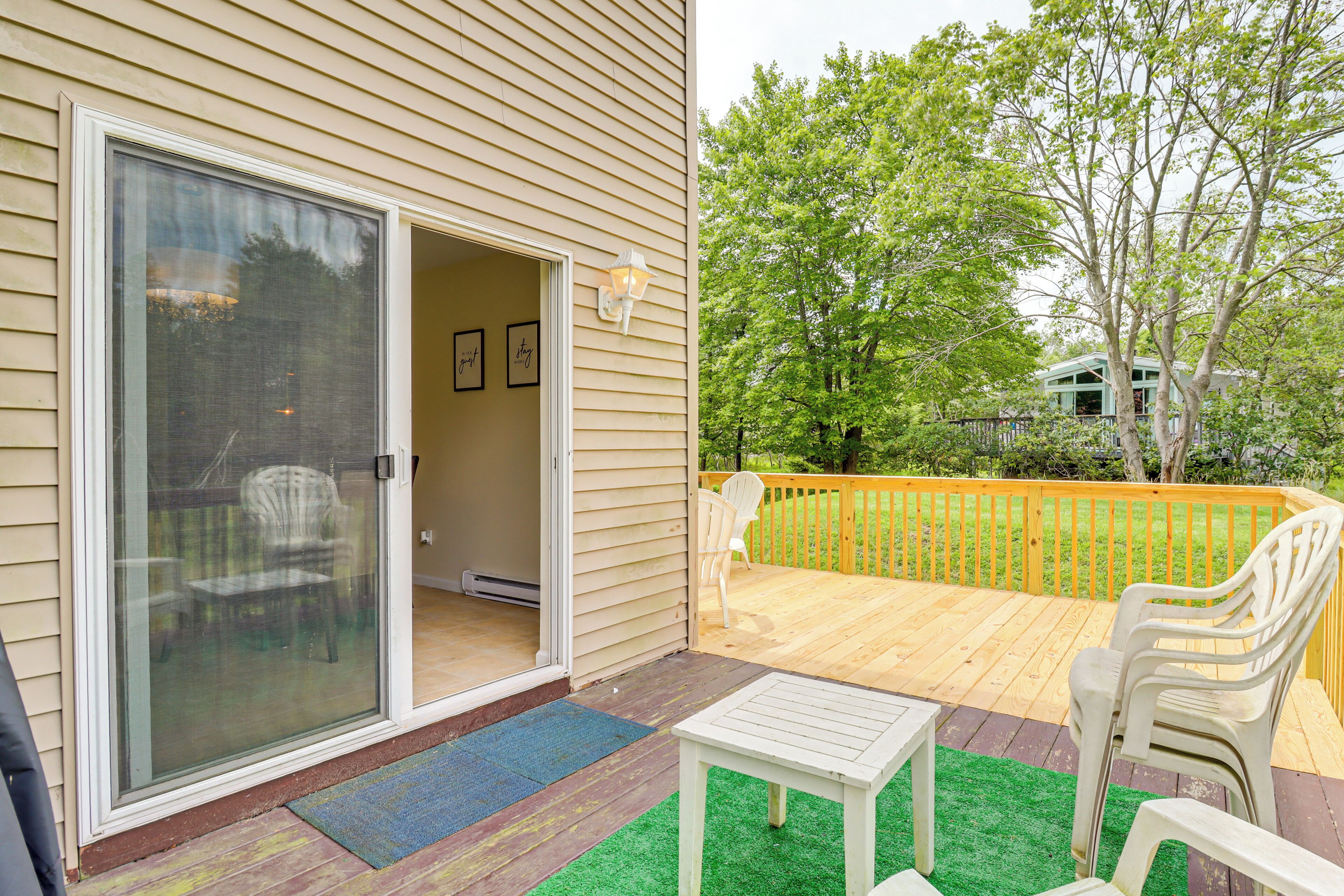 A covered patio with a sliding glass door, a small table, and two chairs.