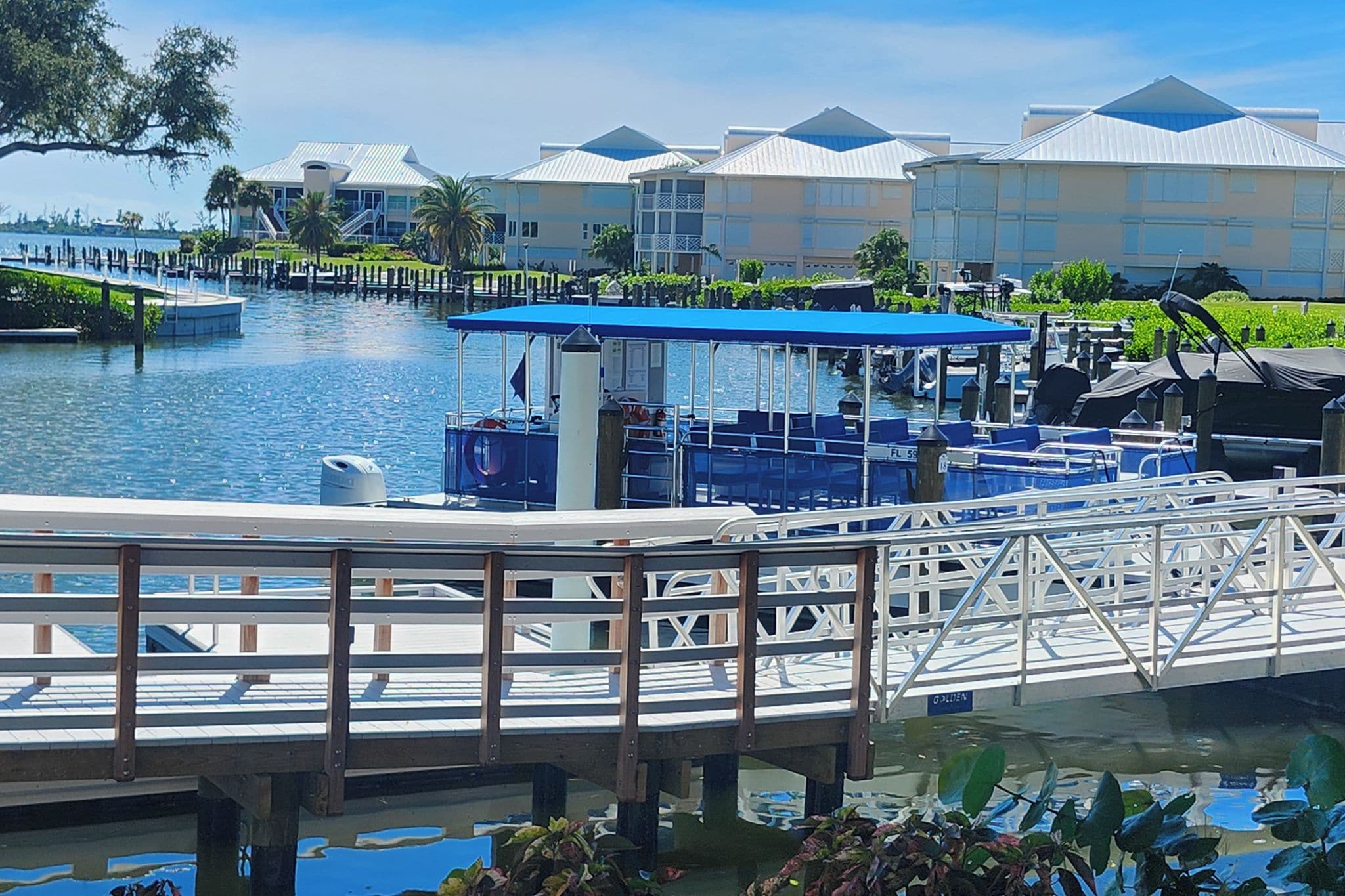 A waterway with a dock and a boat with a blue canopy.