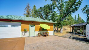 A single-story building with a garage, a covered patio area with a table and chairs, and a vehicle parked nearby. - Fish, Raft & Hike: Southwest OR Couples Retreat! (Trail)
