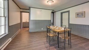 A dining area with a wooden table and chairs, a light fixture on the ceiling, and a door leading to another room. - Walk to Dtwn Bath: Apt Near Keuka Lake & Wine Trl (Bath)