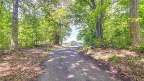 A paved pathway leading to a house surrounded by dense green trees. - Family Home w/ Game Room! 1 Mi to Dale Hollow Lake (Burkesville)