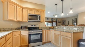 A kitchen with wooden cabinets, a stainless steel oven, a microwave, and granite countertops. - 1 Mi to Wisp Resort: Hot Tub Haven in Mchenry! (McHenry)