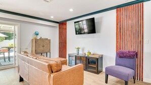 A modern living room with a sofa, a chair, a TV, and a cabinet. - Hacienda Heights Gem w/ Large Patio! (Hacienda Heights)