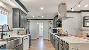 A modern kitchen with stainless steel appliances, a central island, and a view to the outside. - Hacienda Heights Gem w/ Large Patio! (Hacienda Heights)