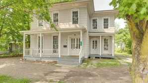 A two-story house with a front porch, a covered entryway, and a large tree in the foreground. - 8 Mi to Keuka Lake: Bath Apt w/ Remote-work Perks! (Bath)