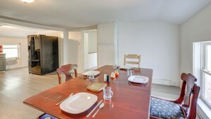 A dining area with a wooden table set for four, including plates, cutlery, and glasses. There is a refrigerator and a window in the background. - 8 Mi to Keuka Lake: Bath Apt w/ Remote-work Perks! (Bath)