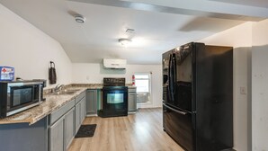 A modern kitchen with granite countertops, stainless steel appliances, and a black refrigerator. - 8 Mi to Keuka Lake: Bath Apt w/ Remote-work Perks! (Bath)