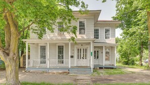 A two-story house with a porch, large windows, and a front door. - 8 Mi to Keuka Lake: Bath Apt w/ Remote-work Perks! (Bath)