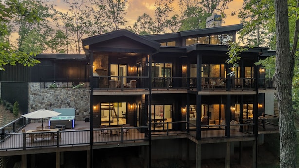 A multi-story building with balconies, outdoor seating, and a pool area.