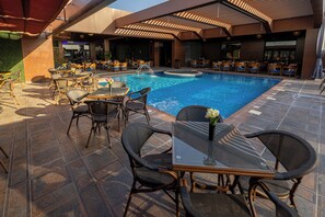 Una piscina al aire libre, camas de piscina gratis, sombrillas