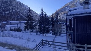 Eine verschneite Berglandschaft mit Gebäuden und einem Holzzaun.