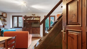 Eine Holztreppe führt zu einem Schlafzimmer auf dem Dachboden mit Blick auf Bäume.