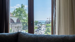 A view from a balcony with a metal railing, a sofa, and a door.