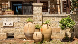 Large terracotta pots, a stone wall, and a sign with directional arrows. - Room 'Sole' with Private Terrace, Wi-Fi and Air Conditioning (Santa Cesarea Terme)