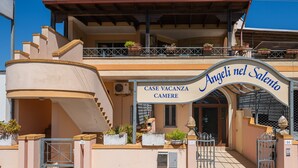 Ein zweistöckiges Gebäude mit einem Schild, auf dem 'Angeli nel Salento CASE VACANZA CAMERE' steht.
