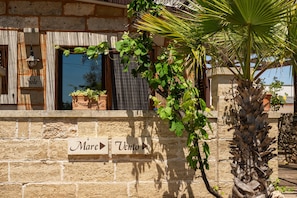 A stone wall with directional signs pointing to 'Mare' and 'Vento.'
