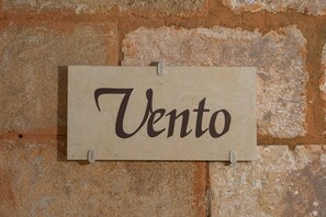 A sign with the word 'Vento' on a textured wall.