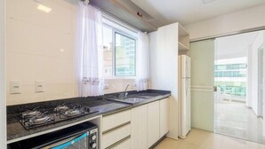 A modern kitchen with a gas stove, oven, and sink. - 450m Beach Apt - Bbq, 3 Suites Tah0602 (Itapema)