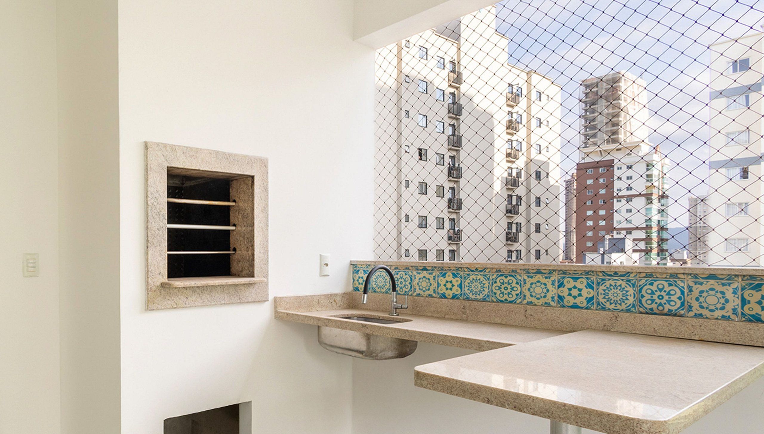 A bathroom with a window, a sink, and a small window with horizontal bars.