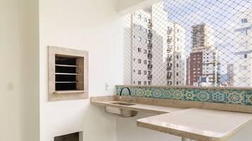 A bathroom with a window, a sink, and a small window with horizontal bars.