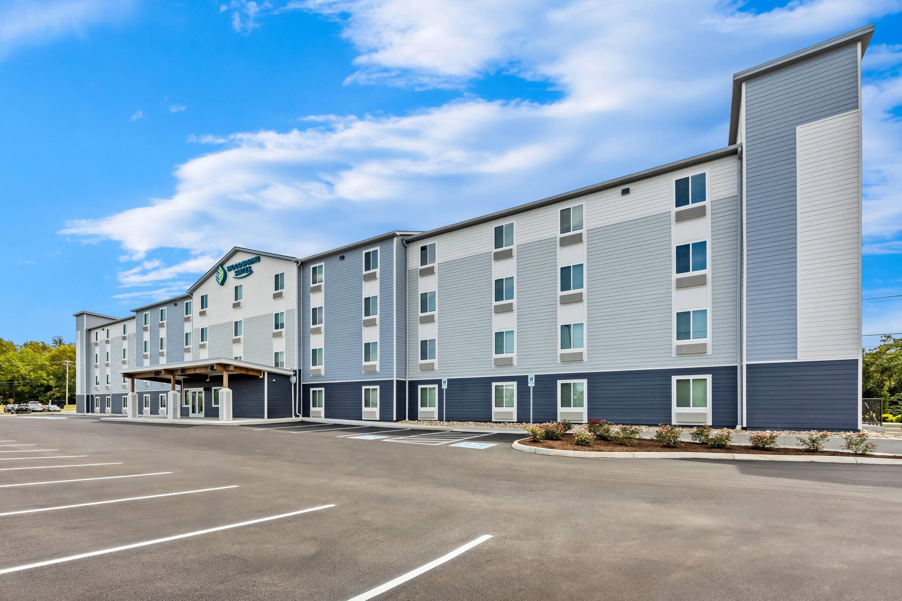 A multi-story hotel with a parking lot in front.