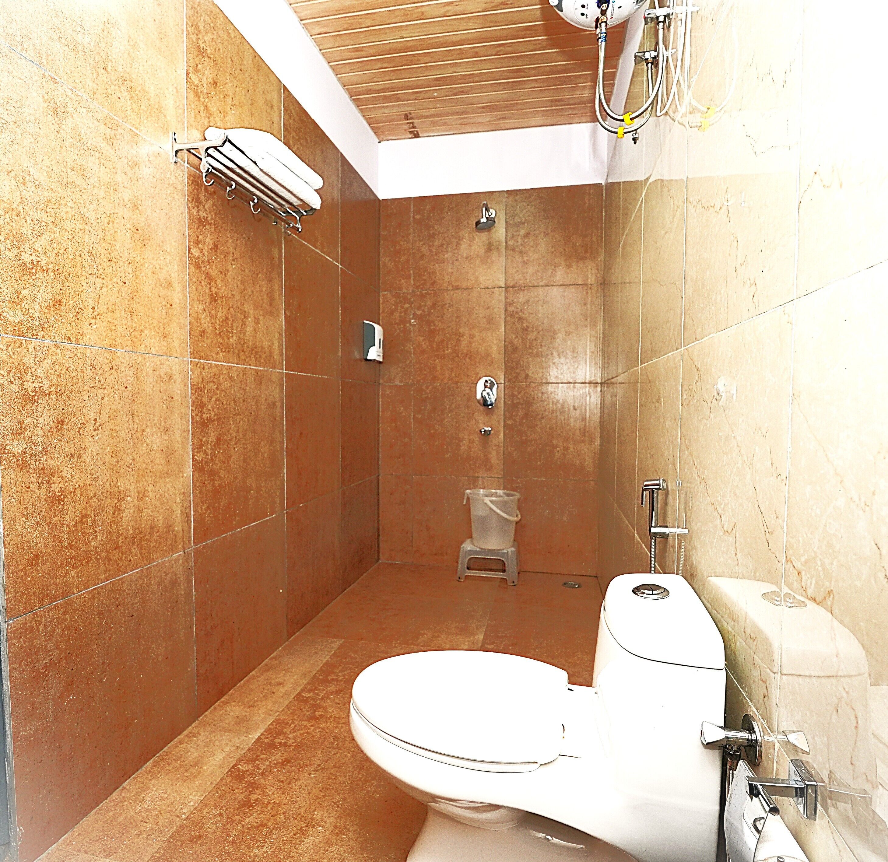 Un baño moderno con ducha, inodoro y perchero.