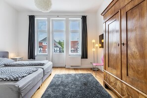 A bedroom with two beds, a wardrobe, a window with curtains, a radiator, and a chair. - Apartment '2' with Wi-Fi (Heide)