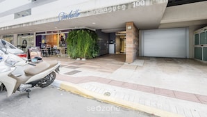 Un edificio moderno con un letrero que dice "Residence 100" y una motocicleta estacionada al frente.