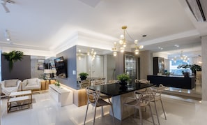 Une cuisine moderne dotée d’un îlot central, de luminaires suspendus et d’un coin repas avec des chaises.