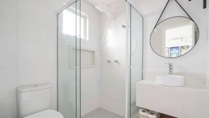 A modern bathroom with a glass-enclosed shower, a white toilet, and a sink with a mirror above it. - 2BR Seaview apt Near Itapema Beach Sem501 (Itapema)