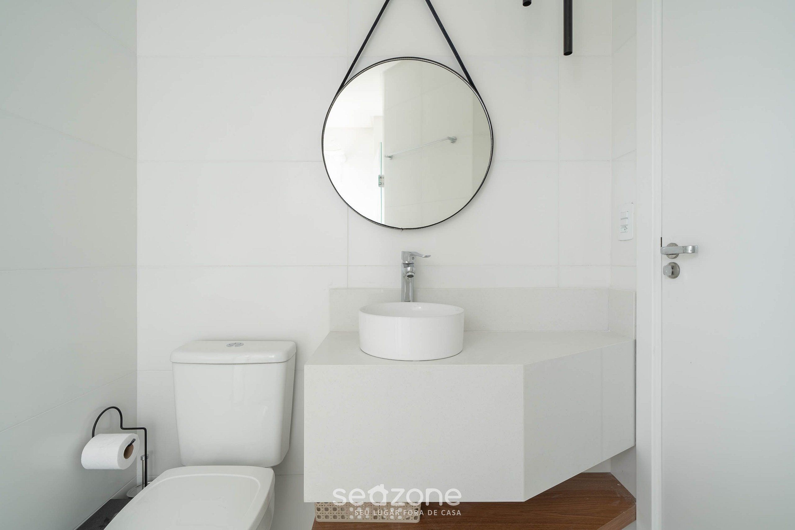 A modern bathroom with a toilet, a sink, and a mirror.
