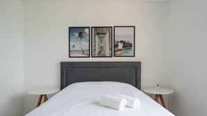 A hotel room with a bed, two bedside tables, and three framed pictures on the wall. - 2BR Seaview apt Near Itapema Beach Sem501 (Itapema)