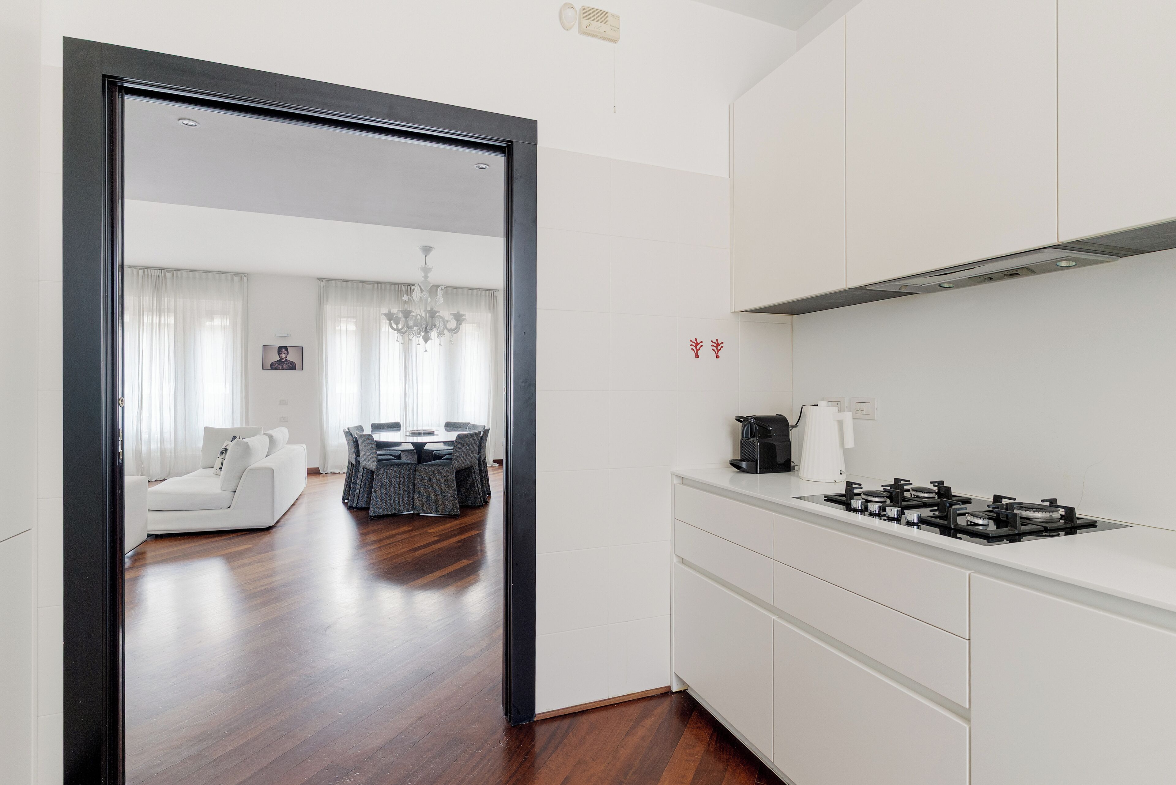 Una cocina moderna con gabinetes blancos y una estufa a gas.