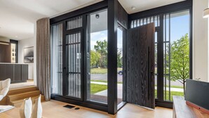 A modern living room with large sliding glass doors, a wooden floor, and a flat-screen TV.