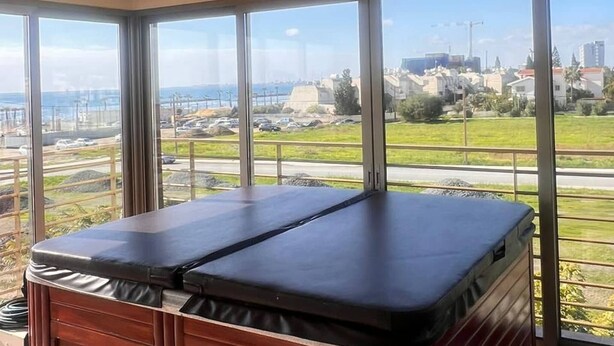 Una habitación con un ventanal grande, un armario de madera y vistas a un paisaje urbano.
